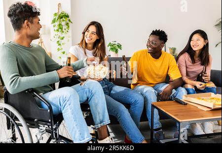 Eine glückliche Gruppe verschiedener Freunde, die auf dem Sofa saßen und zu Hause Spaß hatten Stockfoto