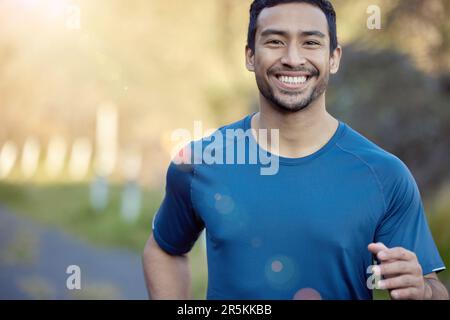 Mann, lächle im Porträt und beim Laufen im Freien, Fitness und Cardio mit Marathon, Sport und Sportlern in der Natur. Asiatischer männlicher Läufer, glücklich mit Bokeh Stockfoto