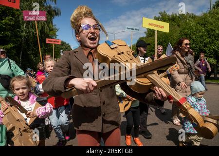 Moskau, Russland. 4. Juni 2023. Erwachsene und Kinder waren Teil der Darbietung des Cardboardia-Projekts, bei dem alle Teilnehmer der immersiven Darbietung Teil des Orchesters mit Musikinstrumenten aus Pappe wurden, im Gorky-Park in Moskau, Russland. Russische Künstler und Künstler helfen Familien mit ihren Pappkreationen und nehmen an der Vorstellung Teil Stockfoto