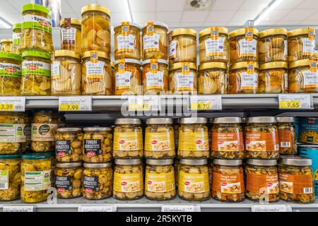 Italien - 31. Mai 2023: Pilze in Öl, die in Glasgefäßen in Regalen im italienischen Supermarkt aufbewahrt werden. cep und Wiesenpilze in Dosen Stockfoto