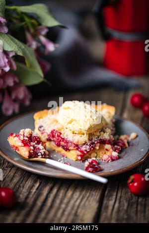 Torte mit saurer Kirschcreme, Creme Patisserie und Krümeln, serviert mit Vanilleeis. Rustikale und stimmungsvolle Atmosphäre und Dekoration. Stockfoto