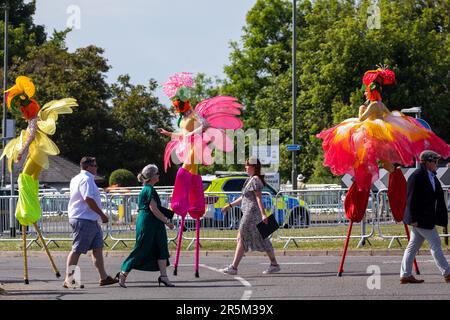 Epsom, 3. Juni 2023. Am Tag des Epsom Derby passieren die Rennfahrer neben den Stiltwalkern vor der Rennbahn Epsom Downs. £150.000 wurden für zusätzliche Sicherheitsmaßnahmen ausgegeben, um einem geplanten Protest von Aktivisten von Animal Rising in Epsom entgegenzuwirken, die Pferderennen als grausame und ausbeuterische Industrie ansehen. Die Polizei von Surrey berichtete, dass 31 Verhaftungen vorgenommen wurden, einschließlich 19 präventiven Verhaftungen. Kredit: Mark Kerrison/Alamy Live News Stockfoto