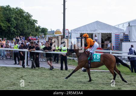 Epsom, 3. Juni 2023. Ein Rennpferd und Jockey-Pass entlang der Rennbahn Epsom Downs zu den Startständen am Tag des Epsom Derby. £150.000 wurden für zusätzliche Sicherheitsmaßnahmen ausgegeben, um einem geplanten Protest von Aktivisten von Animal Rising in Epsom entgegenzuwirken, die Pferderennen als grausame und ausbeuterische Industrie ansehen. Die Polizei von Surrey berichtete, dass 31 Verhaftungen vorgenommen wurden, einschließlich 19 präventiven Verhaftungen. Kredit: Mark Kerrison/Alamy Live News Stockfoto