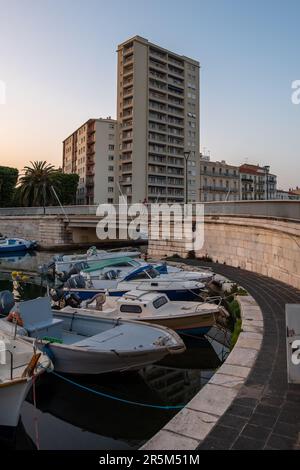 Sete, Frankreich. 26. Mai 2023. Traditionelle Fischerboote liegen an den Kais des Hauptkanals von Sete vor Anker, mit einem beliebten Apartmentblock im Hintergrund die einst Arbeiterstadt Sète mit ihren Werften und der Fischindustrie wird zu einem führenden Touristenziel. Die Gentrifizierung wird durch die Besiedlung von nomadischen Arbeitern und Künstlern beschleunigt, die die Immobilienpreise in die Höhe treiben. (Foto: Laurent Coust/SOPA Images/Sipa USA) Guthaben: SIPA USA/Alamy Live News Stockfoto