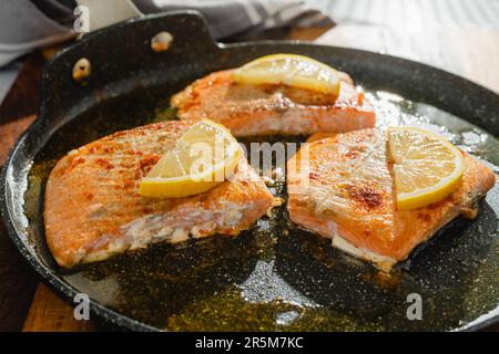 Lachsscheiben mit Gewürzen, geräucherte Paprika und Zitronenscheiben, Nahaufnahme einer Pfanne Stockfoto