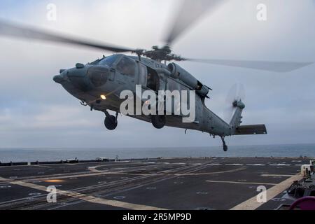 230423-N-EU502-3195 PAZIFIK (23. April 2023) - ein MH-60R Sea Hawk Hubschrauber, der Helicopter Maritime Strike Squadron (HSM) 71 zugewiesen wurde, landet auf dem Cockpit des Guided-Missile Cruisers USS Mobile Bay (CG 53), 23. April 2023. Mobile Bay ist mit der Carl Vinson Carrier Strike Group Diving Group Sail im Gange, die die Fähigkeit demonstriert, die Streikgruppen schnell zusammenzufassen, und die Gelegenheit bietet, Fortschrittsschulungen durchzuführen, um das Niveau der Exzellenz zu verbessern und die Letalität und taktische Kompetenz der USA zu erhöhen Marineeinheiten im Einsatzgebiet der 3. Flotte. (USA Stockfoto