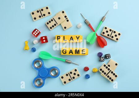 Die Spielsteine mit Wörtern werden auf hellblauem Hintergrund flach gelegt Stockfoto