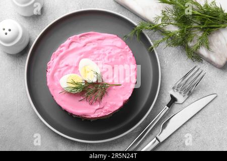 Hering unter Pelzmantel Salat serviert auf hellgrauem Tisch, flach liegend. Traditionelles russisches Gericht Stockfoto