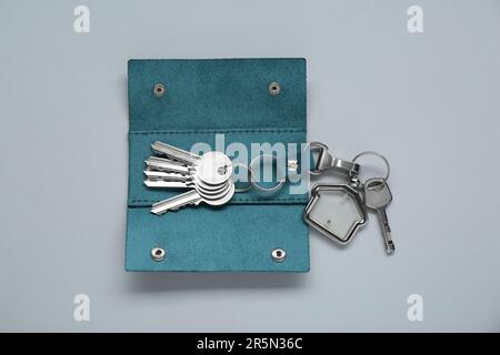 Offener Lederhalter mit Tasten auf hellgrauem Hintergrund, Draufsicht Stockfoto