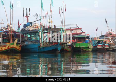 Reihen farbenfroher Fischerboote, die sich nach dem Entladen der Fische ausruhen Stockfoto