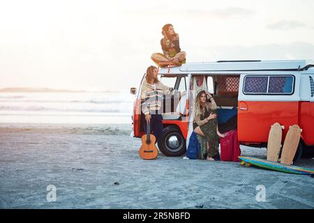 Es gibt nichts Schöneres als frische Meeresluft. Eine Gruppe junger Freunde, die während eines Roadtrips am Strand anhalten. Stockfoto