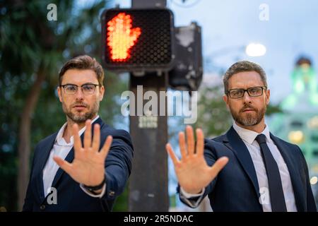 Geschäftsleute hören auf mit der Hand zu singen. Warnausdruck mit negativer und schwerwiegender Geste. Hören Sie auf mit der Hand, der Geschäftsmann sagt, warten Sie. Geschäftlich Stockfoto