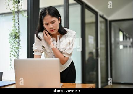 Gestresste und unzufriedene asiatische Managerin oder Geschäftsfrau, die mit ihrem Mitarbeiter telefoniert, um das Problem auf der Website zu beheben. Stockfoto