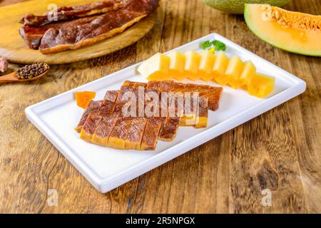 Gedünstetes Schweinefleisch (geräuchertes Schweinefleisch) mit Cantaloupe Stockfoto