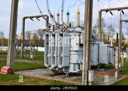 Große Umspannstation für industrielle Eisenmetalltransformatoren mit Transformatoren und Hochspannungselektrik sowie Drähten mit Überspannungsableitern zur Versorgung der Anlage Stockfoto