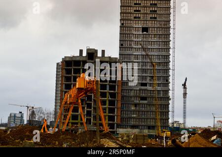 Bau eines großen mehrstöckigen komfortablen Betonzementgebäudes modernes, mehrstöckiges Gebäude mit monolithischem Rahmen und Fenstern, Wänden und Balkonen. Stockfoto
