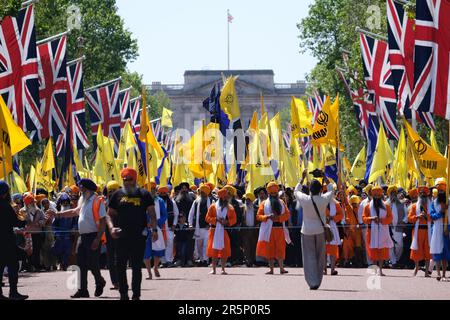 Sikhs begehen den 39. Jahrestag des Massakers am Goldenen Tempel, angeführt von Jüngern stehen vor dem Buckingham Palace, während sie in London marschieren. Stockfoto