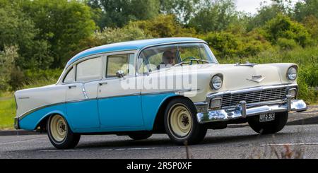 Stony Stratford, Großbritannien - 4. 2023. Juni: Blauer AMERIKANISCHER CHEVROLET-Klassiker aus dem Jahr 1956, der auf einer englischen Landstraße fährt. Stockfoto