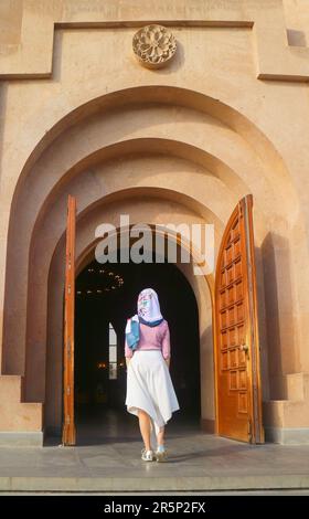 Frau in weißem Kopfschmuck betritt die Kathedrale von Eriwan, die sich im Zentralbezirk von Eriwan, der Hauptstadt Armeniens, befindet Stockfoto