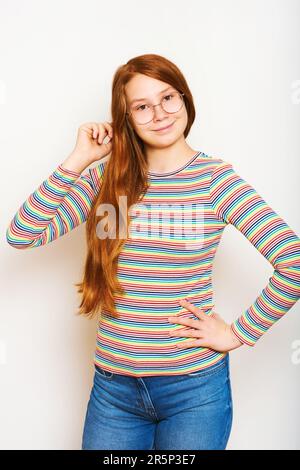 Studio-Porträt eines hübschen jungen Mädchens mit langen roten Haaren, Posen auf weißem Hintergrund Stockfoto