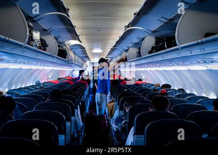 Bangkok, Thailand. 05. Juni 2023. Passagiere verstauen ihr Gepäck über den Sitzen, während sie auf einem Thai AirAsia (FD) Flug von Bangkok, Thailand nach Phnom Penh, Kambodscha am 5. Juni 2023 einsteigen. Kredit: Matt Hunt/Neato/Alamy Live News Stockfoto