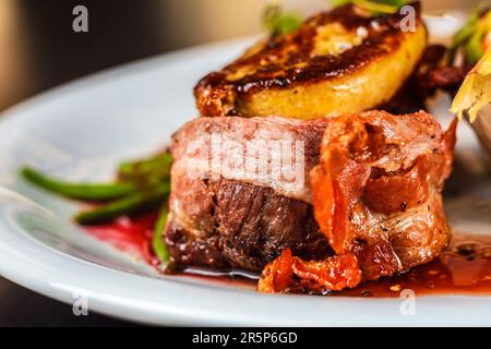 Ein köstliches Abendessen mit geröstetem Rindfleisch, Schweinefleisch und Gemüse, serviert auf einem Teller. Perfekt für gesunde Ernährung! Stockfoto