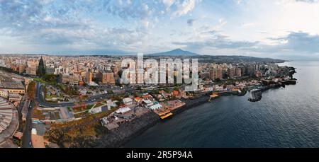 Catanias atemberaubende Schönheit, während der Ätna über das glitzernde Meer blickt. Diese Luftaufnahme zeigt die Skyline der Stadt und den Ätna gegen die coas Stockfoto