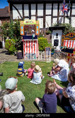 Punch und Judy zeigen die traditionelle und historische Unterhaltung der Kinder auf dem Dorfgrün. England Großbritannien Stockfoto