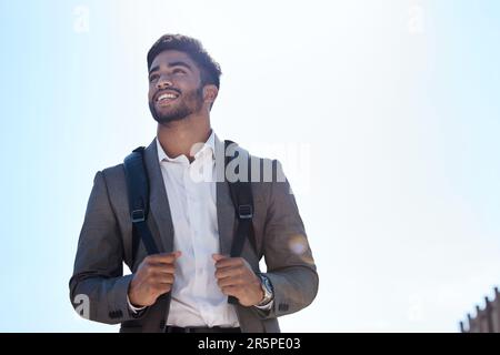 Geschäftsmann, Rucksack und Spaziergänge auf der Straße, in der Stadt und in der Sommersonne mit einem Lächeln und einer Vision. Junger indischer Geschäftsmann, draußen und mit ihm spazieren gehen Stockfoto