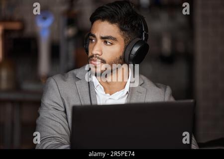 Geschäftsmann, Denker und Café für Fernarbeit mit Kopfhörern auf dem Laptop, Planung und Bericht. Junger indischer Geschäftsmann, Lösung und Brainstorming Stockfoto