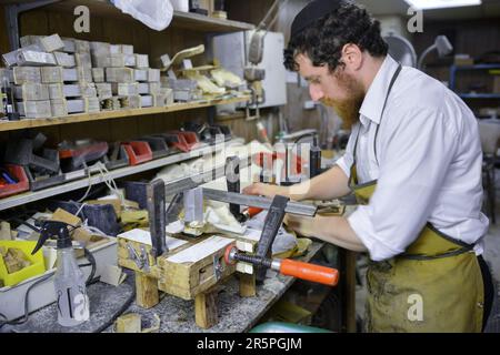 Ein Rabbiner und Meister stellt Tefillin auf traditionelle Weise her. In Brooklyn, New York. Stockfoto