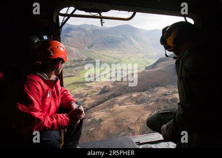 Mitglieder des Langdale/Ambleside Mountain Rescue Teams und ein RAF Whinch Mann in einem RAF Sea King Hubschrauber während einer Rettung in Dungeon Ghyll in den Langdale Pikes, Großbritannien. Stockfoto