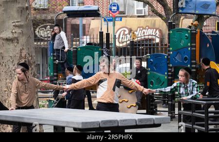 Eine Gruppe orthodoxer jüdischer Jeschiwa-Studenten spielt auf dem Sobel Playground während der Pause von ihrer Jeschiva. In Williamsburg, Brooklyn, New York. Stockfoto