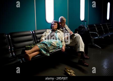Ein anstrengendes Paar ruht sich aus, während es auf seinen Flug nach Livingstone, Sambia, ODER Tambo International Airport in Johannesburg, Südafrika, am 30. Oktober 2007 wartet. Stockfoto