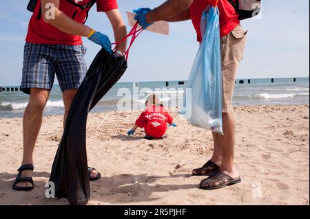 Freiwillige von der Bank of America sammeln Müll am Strand auf, während der International Coastal Cleanup an der North Ave. Strand im Zentrum von Chicago. Stockfoto