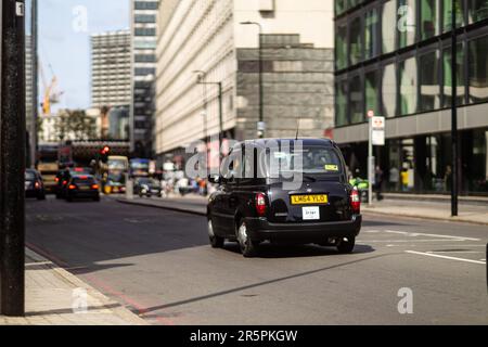London, 29. Mai 2023: Ein klassisches Taxi fährt neben dem Forum Magnum Square. Stockfoto