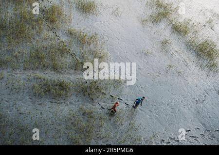 Kalkutta, Indien. 28. Mai 2021. Zwei Jungs laufen in einem trockenen Flussbett am Stadtrand von Kalkutta. Kredit: SOPA Images Limited/Alamy Live News Stockfoto