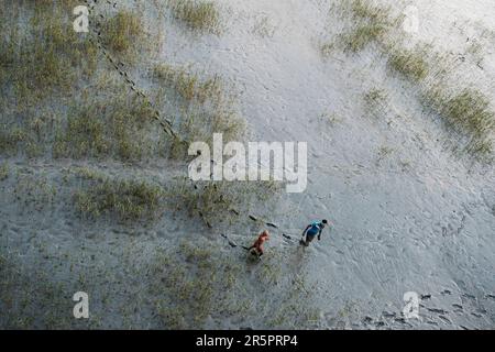 Kalkutta, Westbengalen, Indien. 28. Mai 2021. Zwei Jungs laufen in einem trockenen Flussbett am Stadtrand von Kalkutta. (Credit Image: © Dipayan Bose/SOPA Images via ZUMA Press Wire) NUR ZUR REDAKTIONELLEN VERWENDUNG! Nicht für den kommerziellen GEBRAUCH! Stockfoto