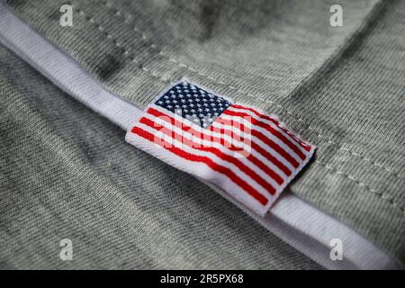 Aufgestickte amerikanische Flagge auf grauem Stoff. USA-Flagge auf grauem Stoffhintergrund. Amerikanische Stickerei. Stockfoto