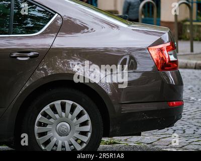 Straßburg, Frankreich - 12. April 2023: Kastanienbraune Topaz Skoda Octavia mit einem beschädigten Flügel, geparkt an einer belebten Straße, reflektiert seine Umgebung auf einer glänzenden Oberfläche und unterstreicht den Transport. Stockfoto