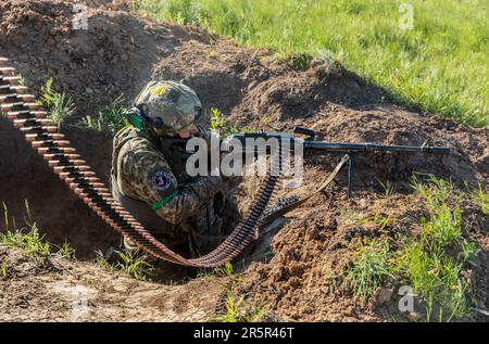 Ein Soldat der ukrainischen Streitkräfte feuert während der Schussübung eine automatische Waffe ab. Erschießungstraining des 128. Territorialen Verteidigungsbataillons der ukrainischen Streitkräfte in der Region Donezk. (Foto: Mykhaylo Palinchak / SOPA Images/Sipa USA) Stockfoto
