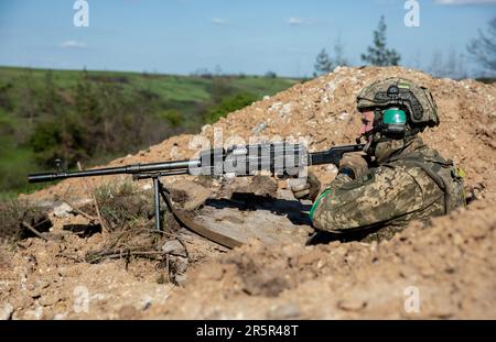 Ein Soldat der ukrainischen Streitkräfte feuert während der Schießübungen eine automatische Waffe ab. Er trainiert das 128. Territoriale Verteidigungsbataillon Kiew der ukrainischen Streitkräfte in der Region Donezk. (Foto: Mykhaylo Palinchak / SOPA Images/Sipa USA) Stockfoto