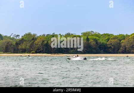 Ein Mann in einem kleinen Motorboot, der vom Mantel der Shelter Island, NY, abfährt Stockfoto