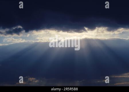 Die stürmischen Wolken erzeugen ein Gefühl von Drama, wenn sie sich während des Sonnenuntergangs über den Himmel bewegen. Stockfoto