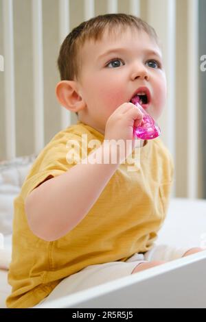 Die Zahnhygiene des Babys wird beim Zähneputzen im Kinderbett beachtet. Kind im Alter von etwa zwei Jahren (ein Jahr und elf Monate) Stockfoto