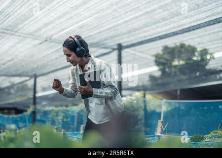 Landarbeiter verbessern die gesunde Work-Life-Balance, indem sie Musik hören und den Körper zum Beat und Rhythmus bewegen. Flexible Arbeitszeitgestaltung, t Stockfoto