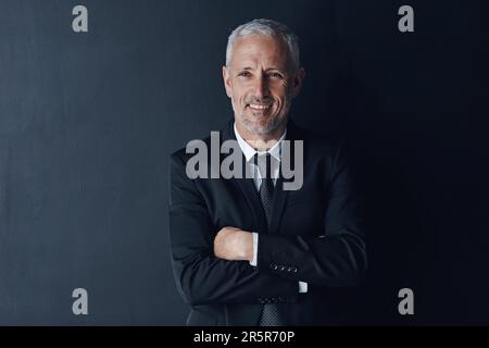 Die richtige Einstellung macht den entscheidenden Unterschied im Geschäft. Studiofoto eines erwachsenen Geschäftsmanns vor dunklem Hintergrund. Stockfoto