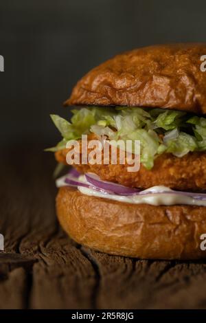 Ein köstliches Hühnchen-Sandwich mit einem saftigen Hähnchenpastete auf frisch gebackenem Brot und knusprigem Salat Stockfoto