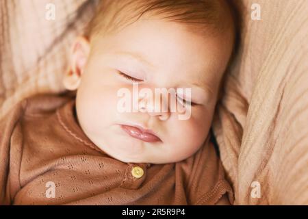 Nahaufnahme des süßen Babys, das im Buggy in warmem Licht schläft Stockfoto