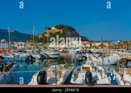 Denia, Alicante, Spanien. 22. Mai 2022 - Segelboote und andere Boote liegen im Yachthafen vor. Im Hintergrund: Hotels und Restaurants in der Altstadt, und Stockfoto